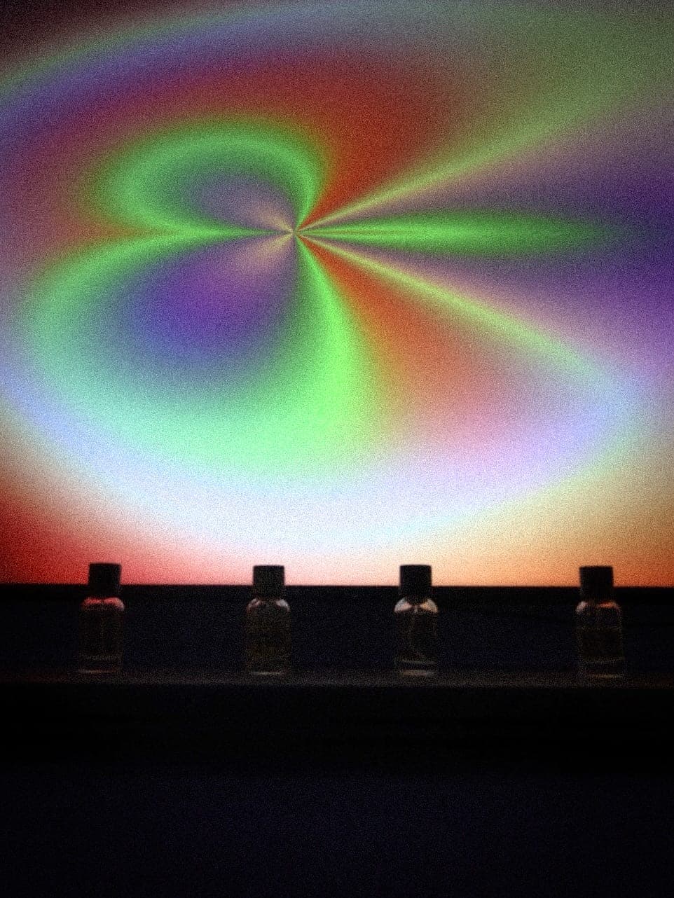 A visual across the wide screen, perfumes lined up below